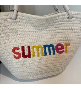 Close-up of colorful summer embroidery and woven texture on this large cream tote bag