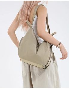 Side view of beige large capacity backpack showing functional side zipper and soft canvas texture