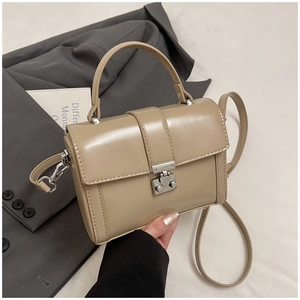 Detail shot of the khaki square crossbody bag featuring a silver metal twist lock closure