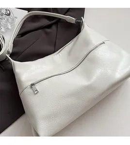 Close-up of white crossbody tote featuring cracked texture PU leather and silver metal zipper
