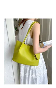 Detailansicht einer zitronengelben Shopper-Tasche aus Leder, getragen von einem Modell
