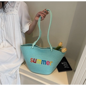 Close-up of light blue woven tote bag with colorful 'summer' embroidery and slim handles