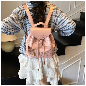 Pink cartoon bear printed backpack with MY BAGS logo shown worn by a model in a stairwell