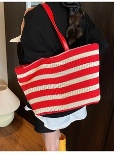 Borsa tote intrecciata a righe bianche e rosse con manici in pelle rossa su modella