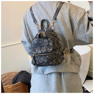 Mini multi-functional backpack with floral pattern shown on model in a modern room