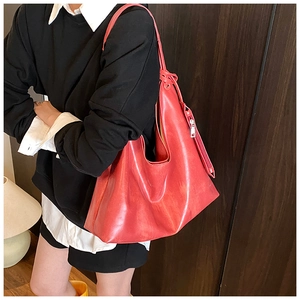 Detail of red faux leather tote bag with minimalist matte finish and side zipper detail