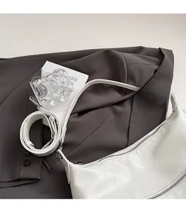 Close-up of white wrinkled leather shoulder bag with a metal zipper and long strap