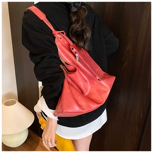 Slouchy red leather tote bag with knotted shoulder strap detail and vintage texture finish