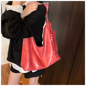 Detail of red large capacity tote bag with matching small zippered pouch on model
