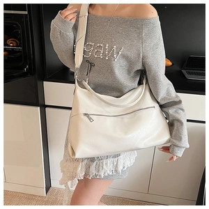 Close-up of a white large Hobo bag with adjustable wide strap and zipper pocket detail