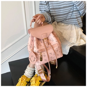 Detailed shot of pink mini backpack with bear prints and a smiley face charm on a model
