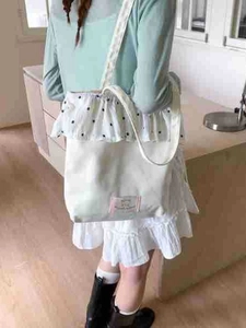 Canvas tote bag with polka dot ruffle trim shown on model for daily commute use