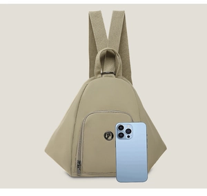 Khaki triangle backpack detail with front zipper pocket and smartphone for size scale