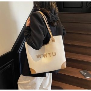 Close-up of contrast large tote bag with textured faux leather and 3D gold letters