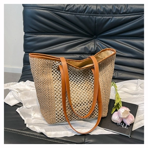 Detail view of straw woven tote bag featuring hollow diamond mesh and tan leather straps