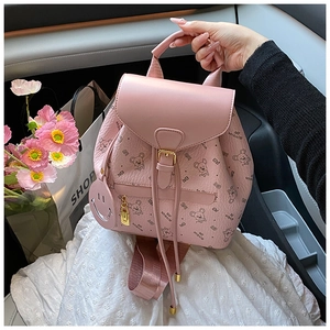 Detailed view of pink leather backpack with cartoon pattern and drawstring closure