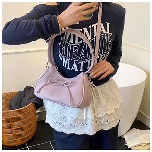 Detail of lavender hobo bag with bow tie and lychee texture shown in a mirror selfie