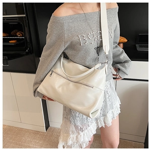 Detail of white PU leather tote with litchi texture and adjustable wide shoulder strap