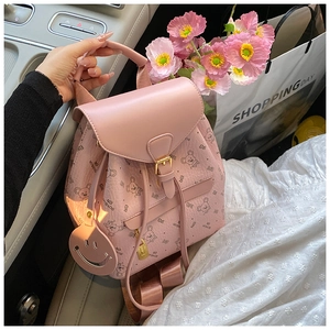 Detailed macro view of pink backpack with cartoon bear prints and golden metal buckle