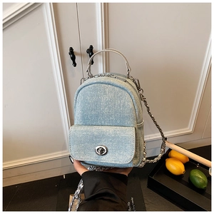 Mini light blue washed denim backpack with silver hardware and leather handle detail