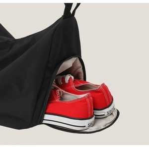 Detail view of large black travel bag featuring a built-in separate shoe compartment