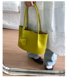 Detailansicht einer leuchtend gelben Ledertasche mit Textur als Schultertasche