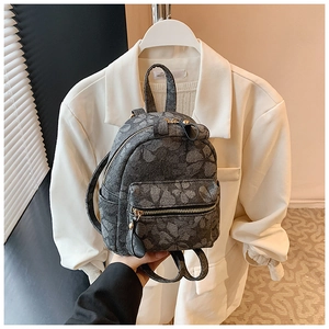Detail of a mini grey backpack with grey floral jacquard fabric and metal zipper