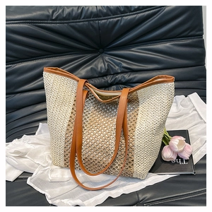 Detail of hollow woven texture and brown leather strap on summer beach tote bag