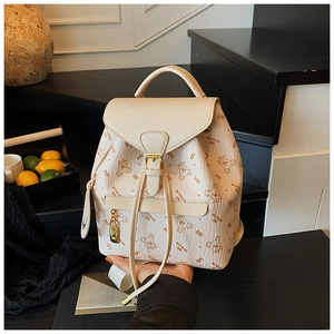 Detail of cream leather backpack featuring brown bear print and MYBAOB lettering