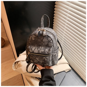 Detail view of mini jacquard floral backpack with metallic zippers and top handle