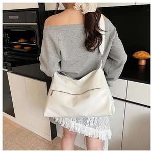 Detail showing the white lychee grain texture and silver metal zipper on the shoulder bag