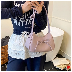 Close-up of lavender shoulder bag with textured faux leather and bow detail