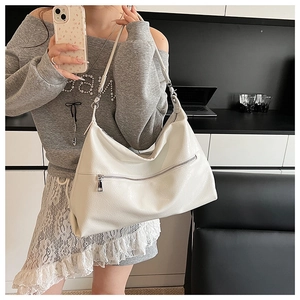 Macro shot of white PU leather texture and silver zipper detail on large shoulder bag