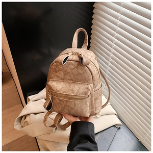 Detail of vintage brown mini backpack with floral pattern and golden metal zippers