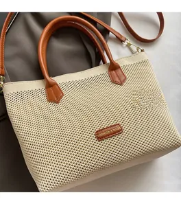 Détail du sac cabas tissé montrant la texture blanche et l'étiquette en cuir FASHION & BAGS