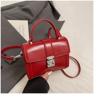 Detail of red square handbag with silver metal buckle and detachable shoulder strap