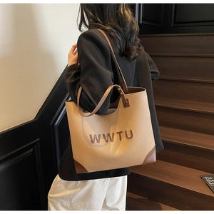 Detailed side view of large vintage tote bag with WWTU logo and dark brown handles