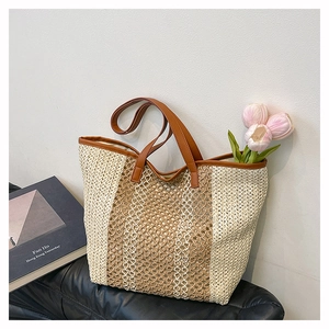 Detail of woven straw beach tote featuring leather handles and intricate mesh texture