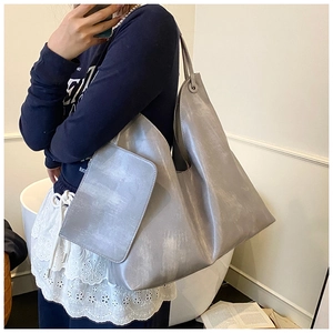 Detailed macro view of a silver tote bag with metallic coating and matching accessory pouch
