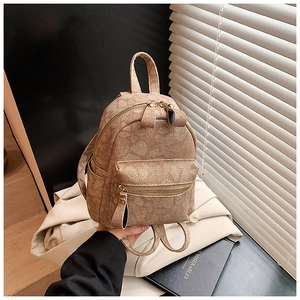 Detail of vintage floral embossed texture on a brown faux leather mini backpack