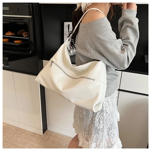 Detail view of the white textured faux leather hobo bag with a silver zipper pocket