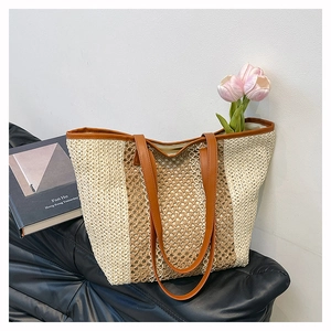 Detail view of the hand-woven beach tote bag showing leather handles and woven texture