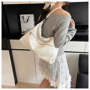 Detail of white glossy leather tote bag with fine texture and stylish side zipper