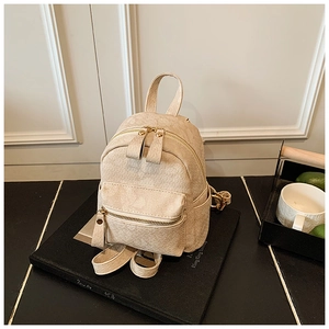 Detail view of cream mini backpack showing textured leather and elegant gold zipper hardware