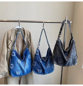 Detailed view of large denim hobo tote bags with frayed letter patches in three colors