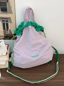 Pastel purple nylon crossbody bag with green drawstring trim and braided shoulder strap