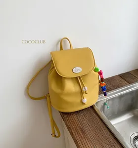 Detail of yellow pebbled leather mini backpack with rabbit logo and rainbow bead charm
