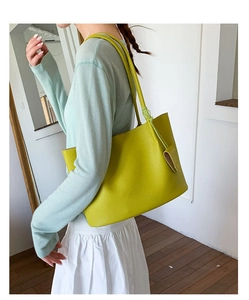 Detailansicht der großen neongrünen Shopper-Tasche mit Lederstruktur an einem Model