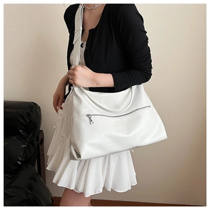 Detailed view of the white lychee texture leather and front zipper on a large tote bag