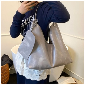 Detail view of grey faux leather tote bag with matching pouch and knotted handles